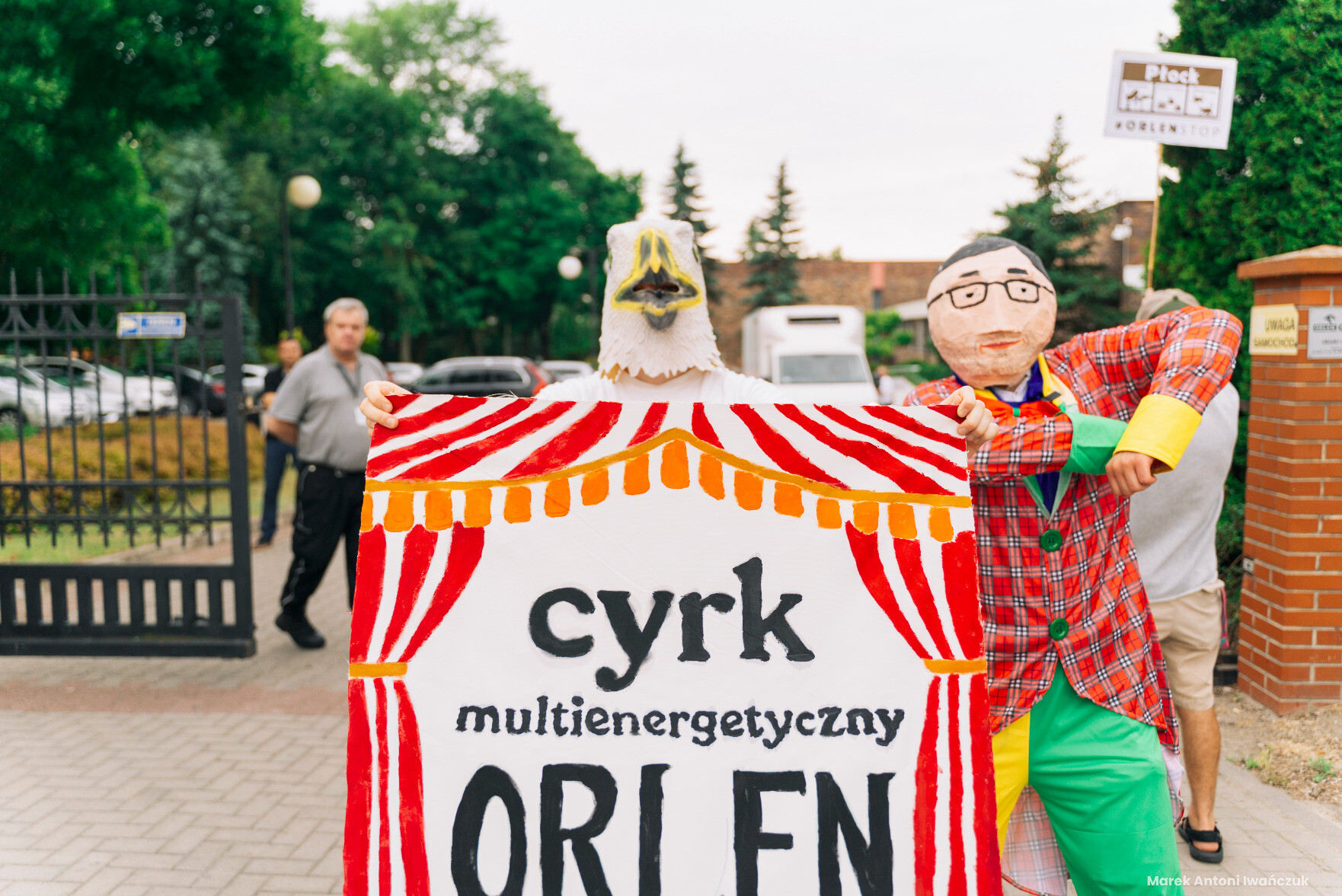 Osoby w przebraniu orła i Obajtra-błazna z transparentem "cyrk multienergetyczny Orlen"