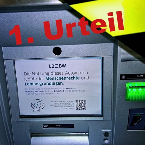 Geldautomat mit Zettel und Absperrband überklebt und der Überschrift in rot:
1. Urteil
Auf den Zettel steht:
"LBBW
Die Nutzung dieses Automaten gefährdet Menschrechte und Lebensgrundlagen.
Mit ihrem Geld finanziert die LBBW die Kohle- und Rüstungsindustrie. Zu ihrer Sicherheit wurde daher dieser Automat außer Betrieb genommen.
https://www.urgewald.org/"