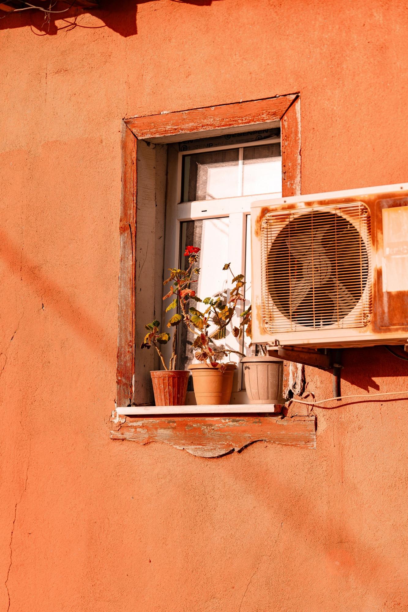 Fenêtre au milieu d'un mur rouge-orangé agrémentée d'un bloc de climatisation - Image libre de droit (sans utilisation commerciale) de Şahin Doğdu Fenêtre au milieu d'un mur rouge-orangé agrémentée d'un bloc de climatisation - Image libre de droit (sans utilisation commerciale) de Şahin Doğdu